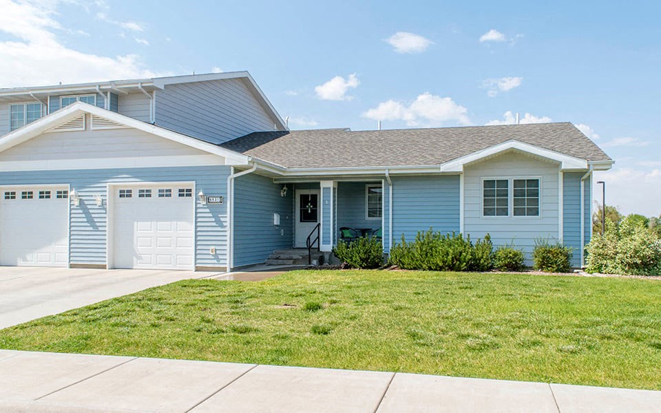 a blue house with a lawn in front of it
