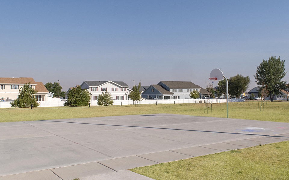 a parking lot with houses in the background