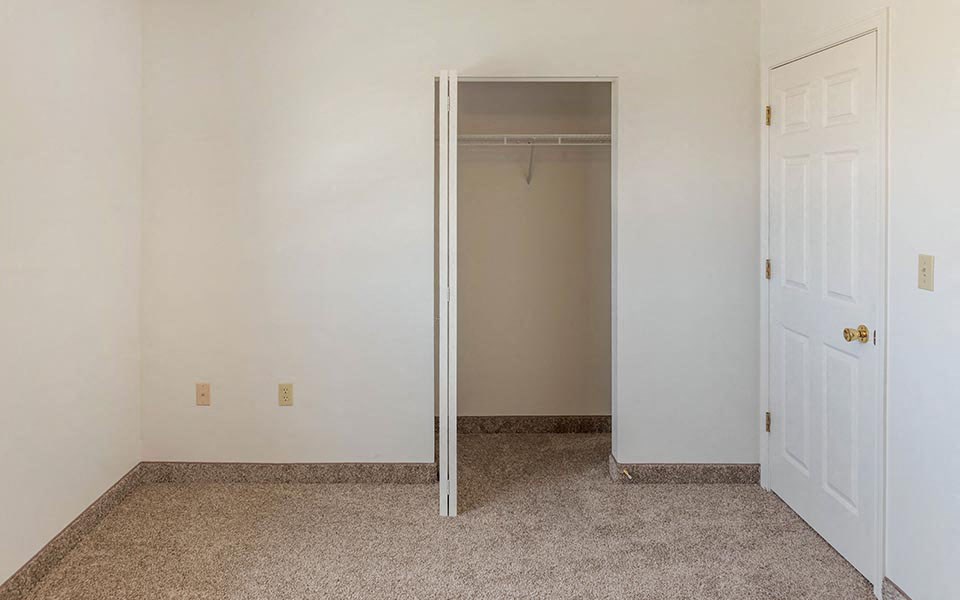 an empty room with a closet and a door
