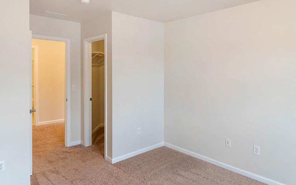 an empty bedroom with white walls and a closet