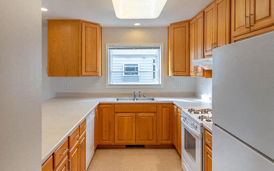 a kitchen with wooden cabinets and a sink and a refrigerator