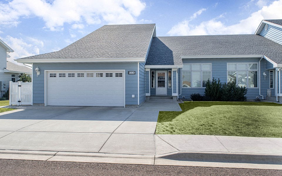 a blue house with a driveway and a garage door