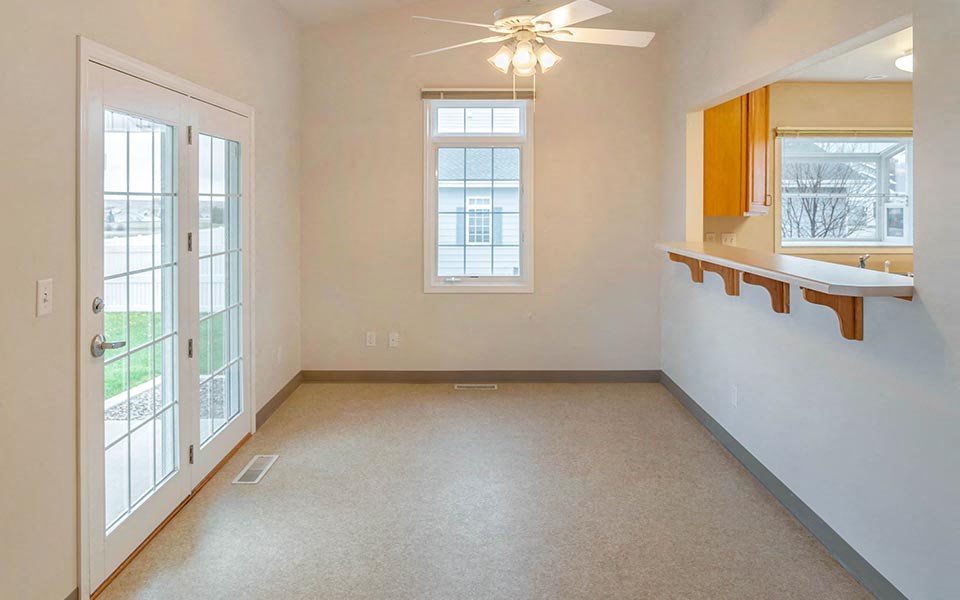 an empty living room with a door to a balcony