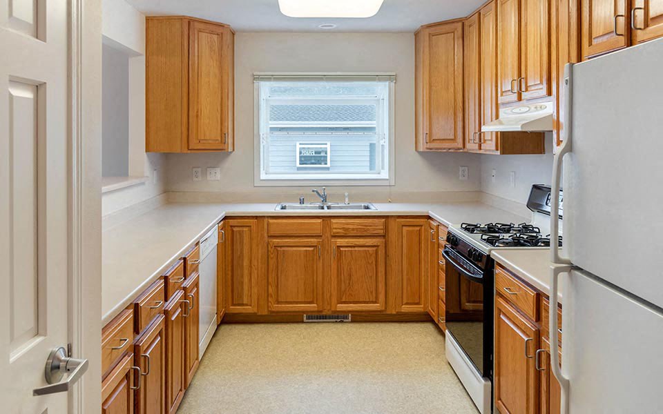 a kitchen with wooden cabinets and a stove and a refrigerator