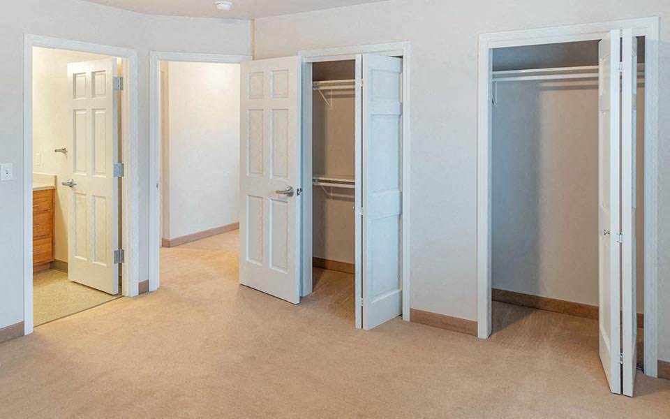 an empty room with several closets and doors