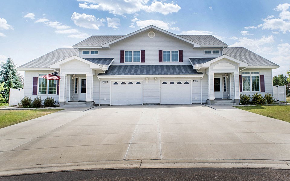 a large white house with a garage with a driveway