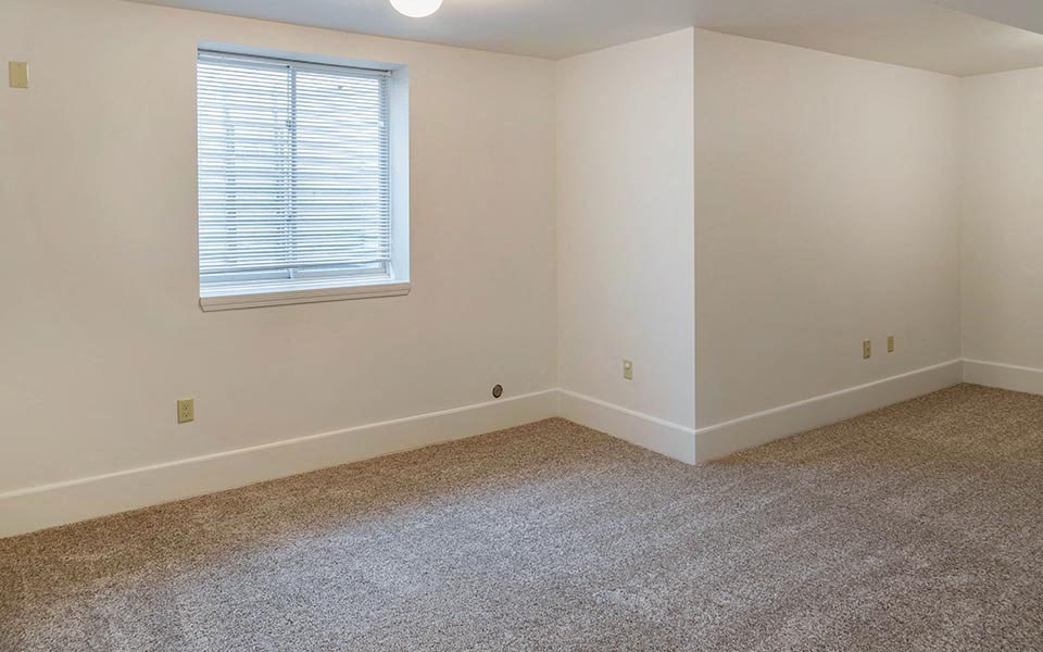 an empty room with carpet and a window