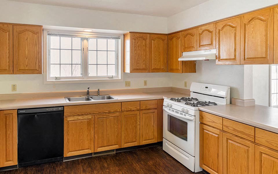 a kitchen with wooden cabinets and a stove and a sink