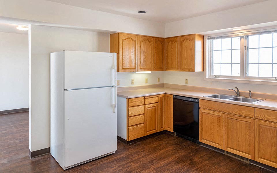 a kitchen with a white refrigerator and wooden cabinets