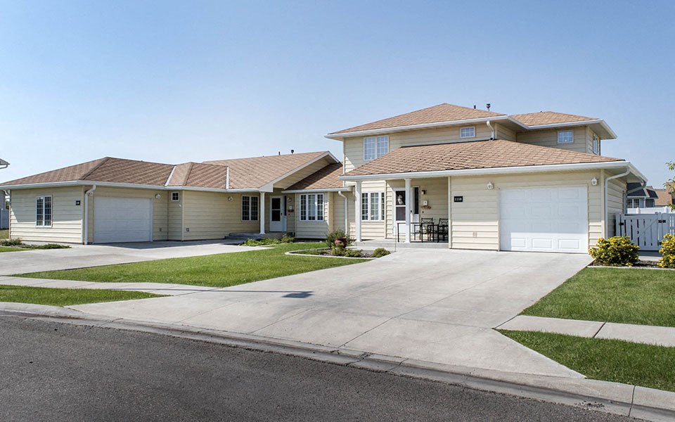 a house with white garage doors and a driveway