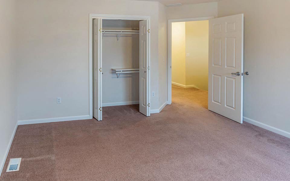 an empty room with a closet and a door