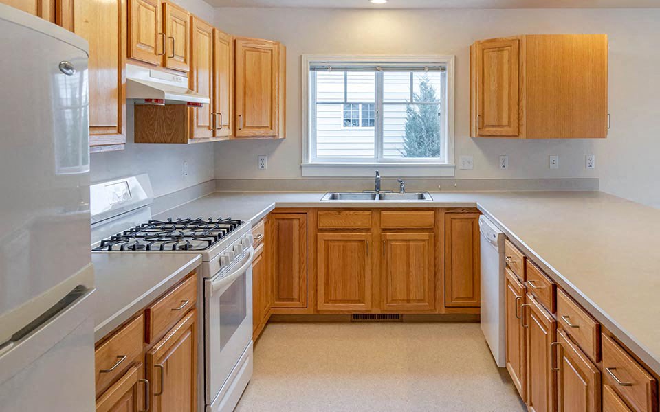 a kitchen with a stove and a sink and a window