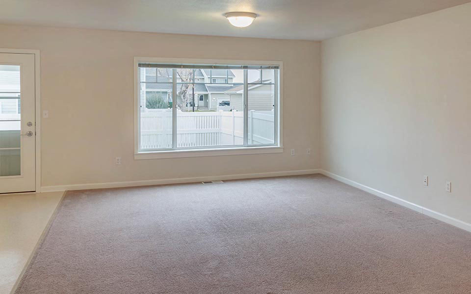 an empty living room with a large window