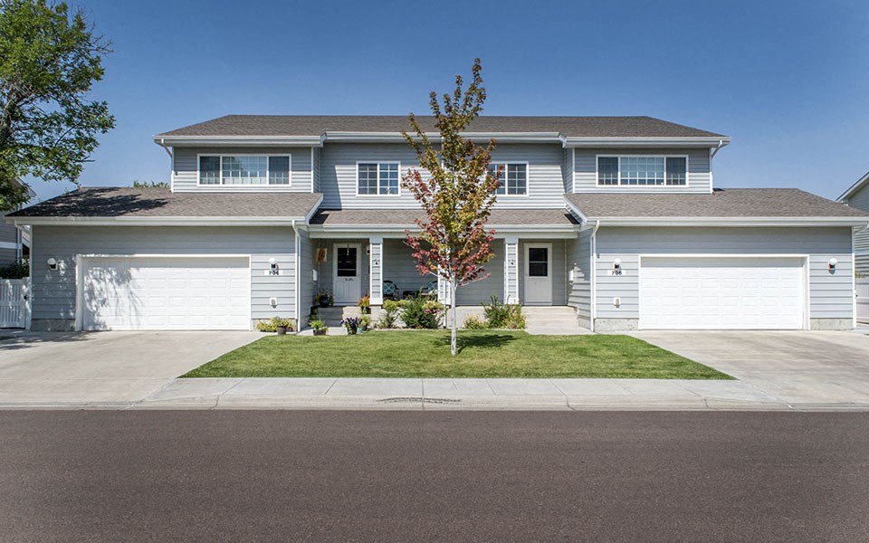 a blue house with white doors and a lawn