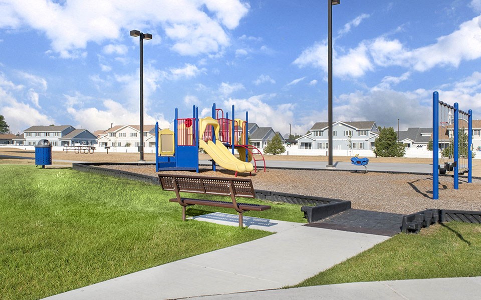 a playground at a park with a blue and yellow slide