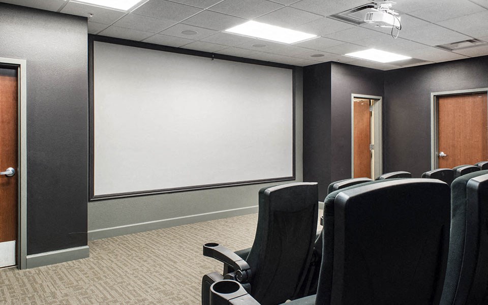 a conference room with chairs and a projector screen