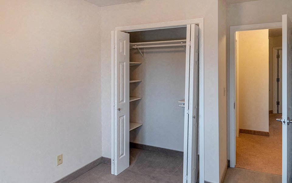 an empty closet in a room with an open door