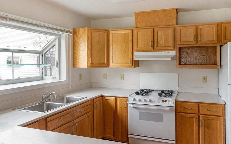 a kitchen with a stove and a sink and a window