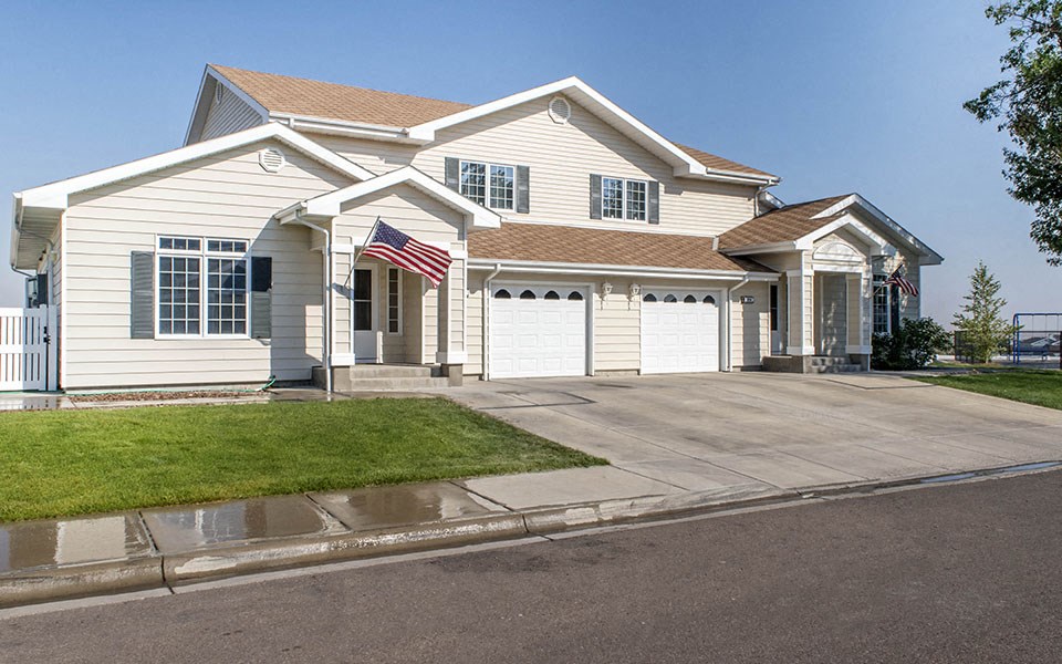 a white house with an flag on the driveway
