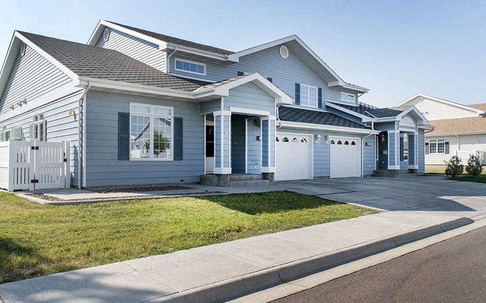 a blue and white house with a sidewalk in front of it