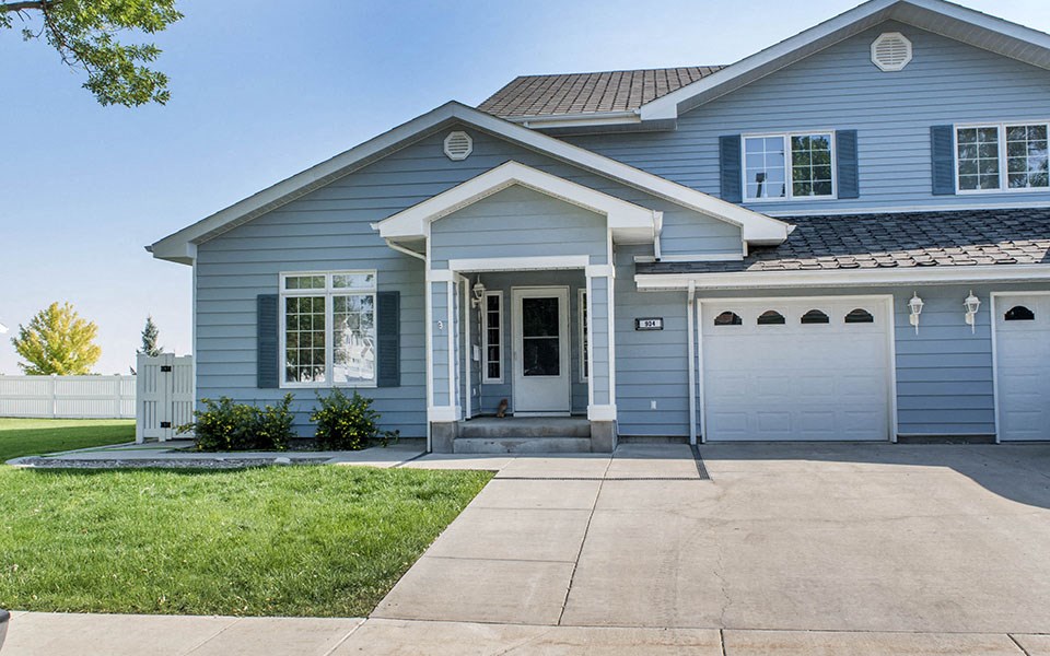 a blue house with a driveway and a white garage door