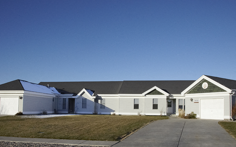 a white house with a gray roof and a driveway