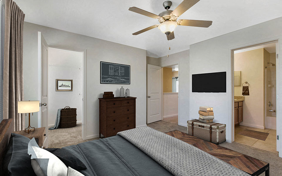 a bedroom with a large bed and a ceiling fan