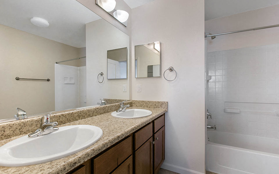 a bathroom with two sinks and a shower