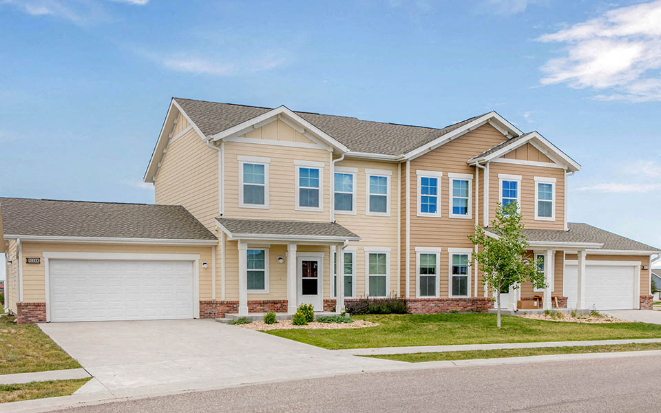 a beige house with a garage and a driveway