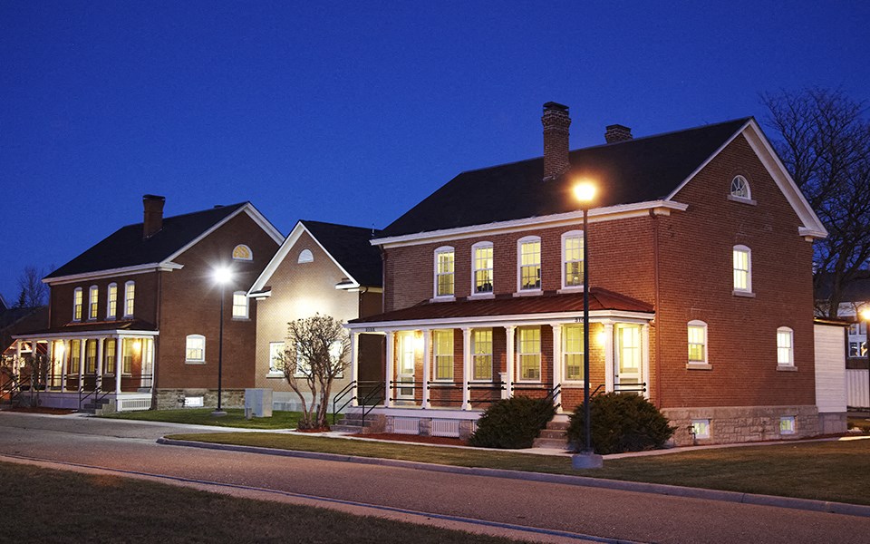the house at night with lights on in the front porch
