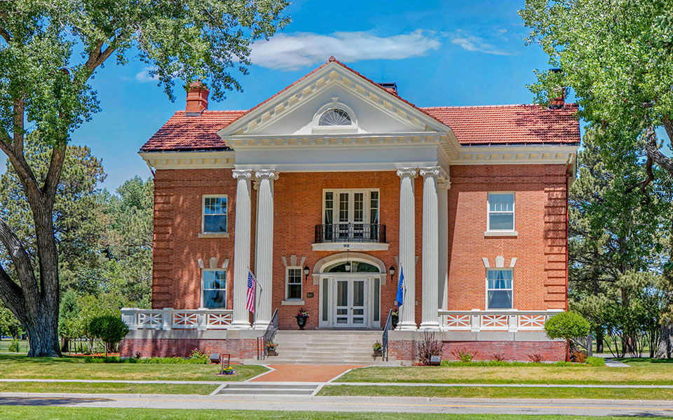 a large brick building with columns and a red roof