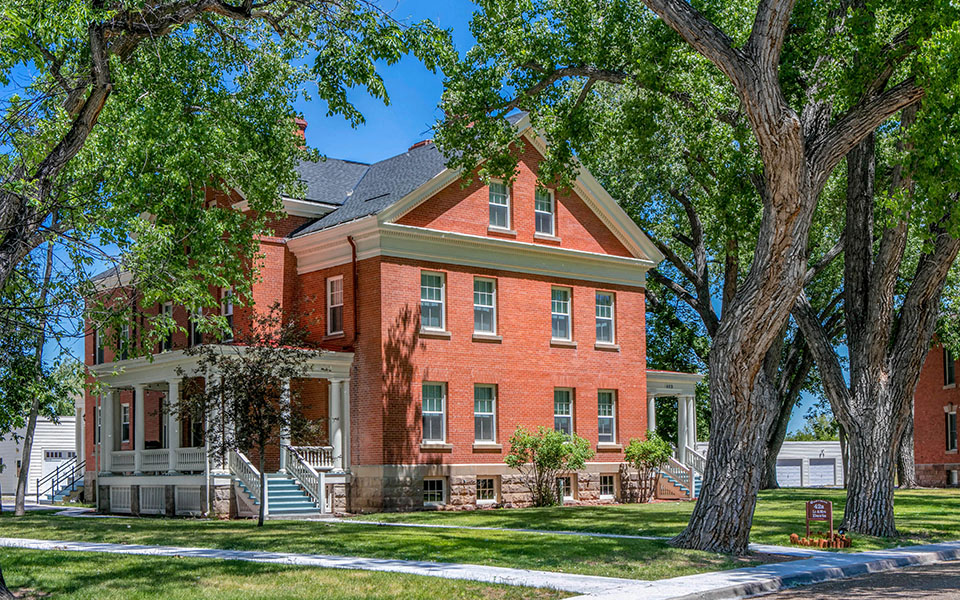 a large brick house with trees in front of it