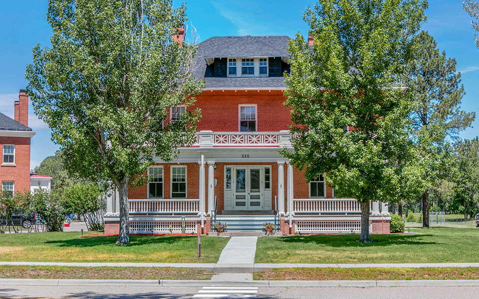 a red brick house with trees in front of it