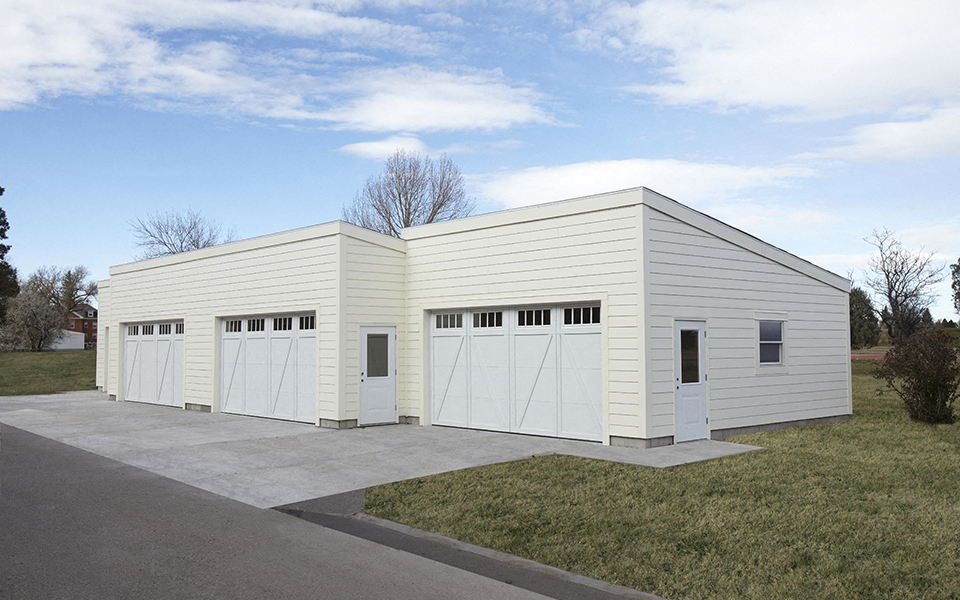 a small white building with two garage doors
