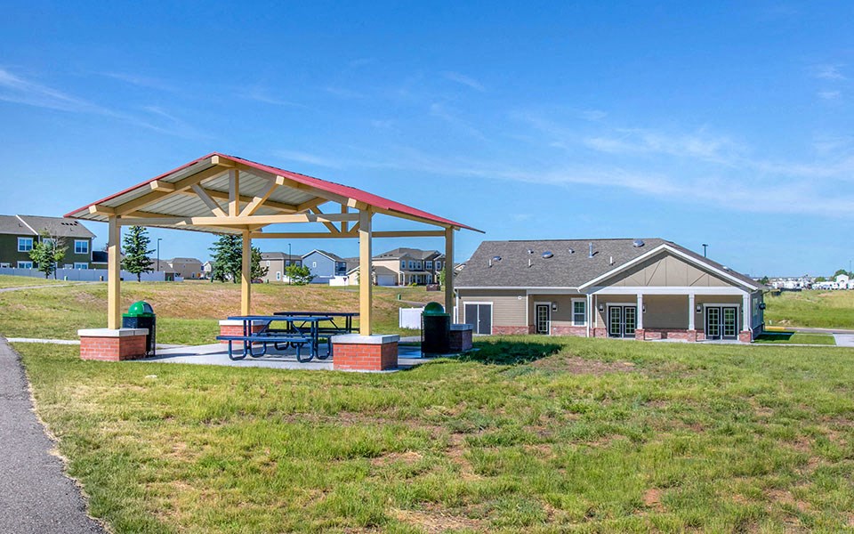 a picnic area with a picnic table in front of a house