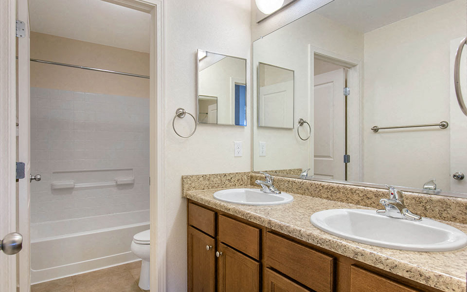 a bathroom with two sinks and a shower and a toilet