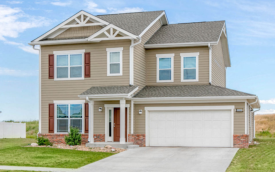 a tan house with a white garage door