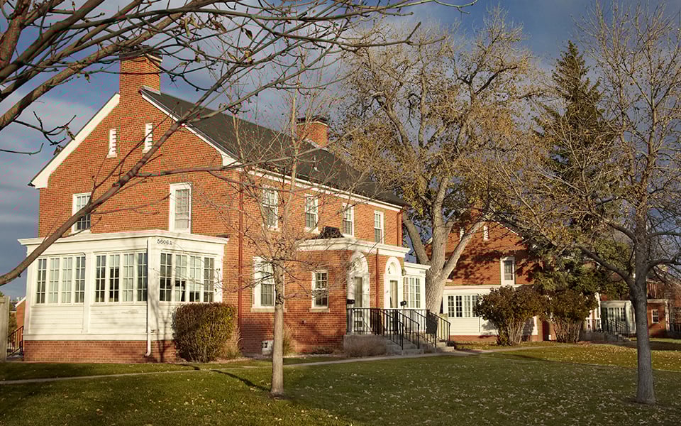 a red brick house with trees in front of it