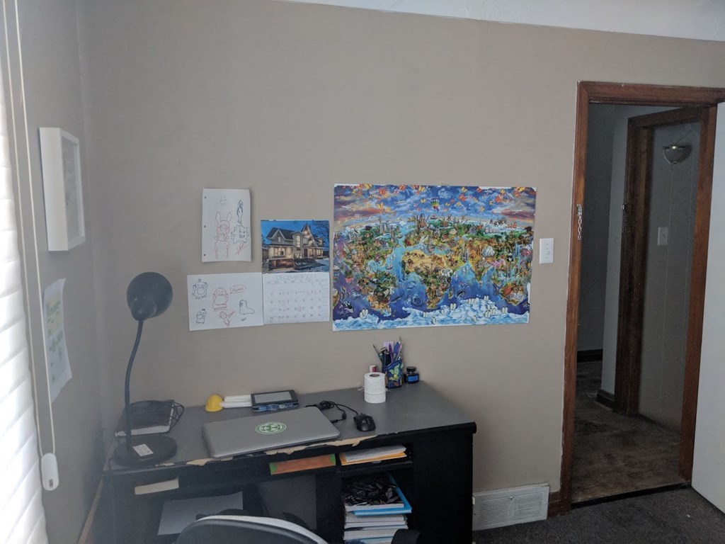 an office with a desk and a painting on the wall
