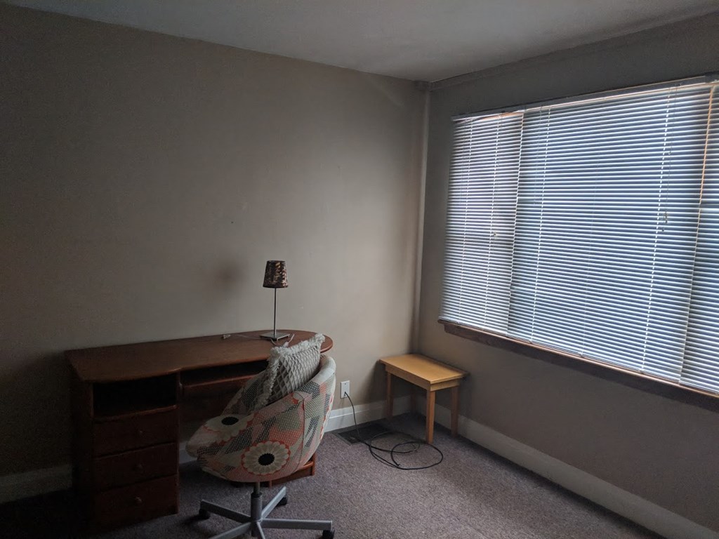 a room with a desk and a chair and a window