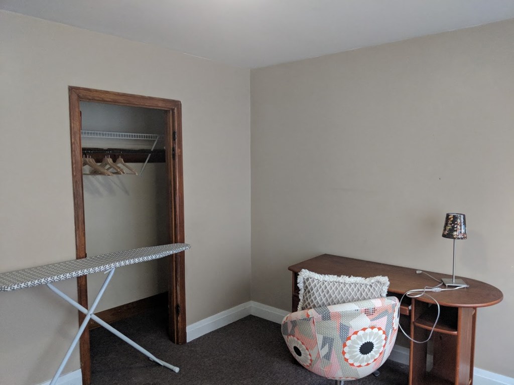 a small room with a desk and a chair and a mirror