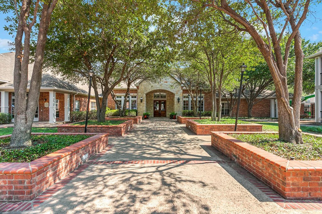 a courtyard with trees in front of a building