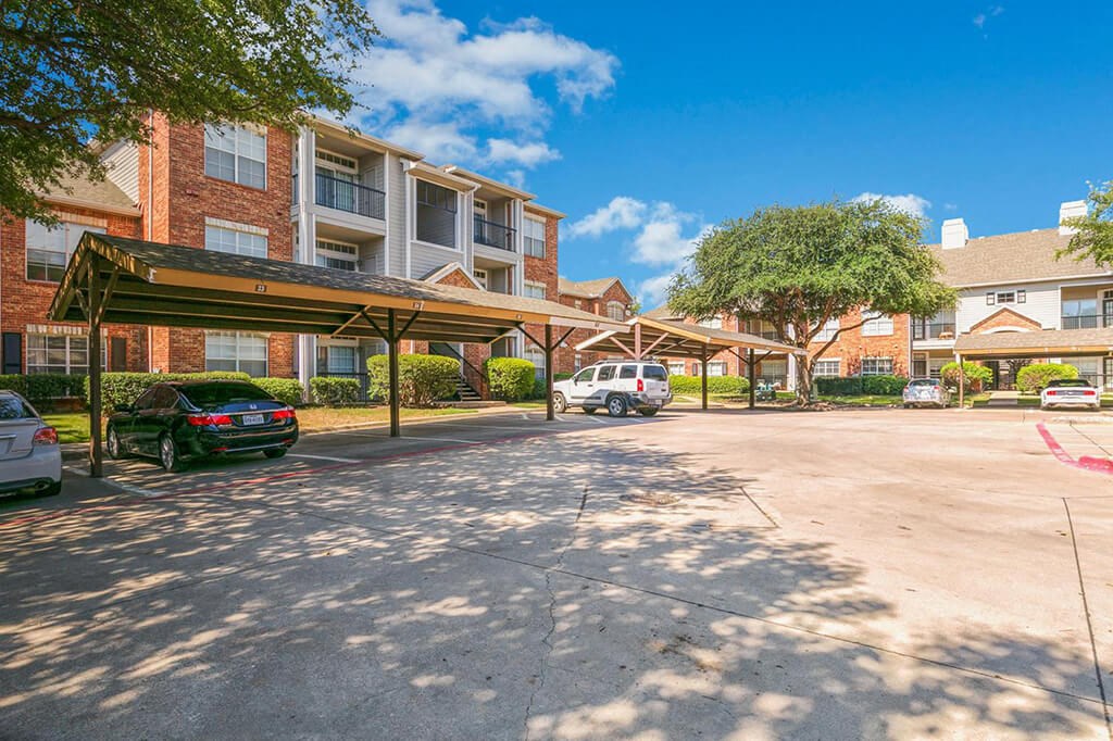 a parking lot with cars in front of an apartment building
