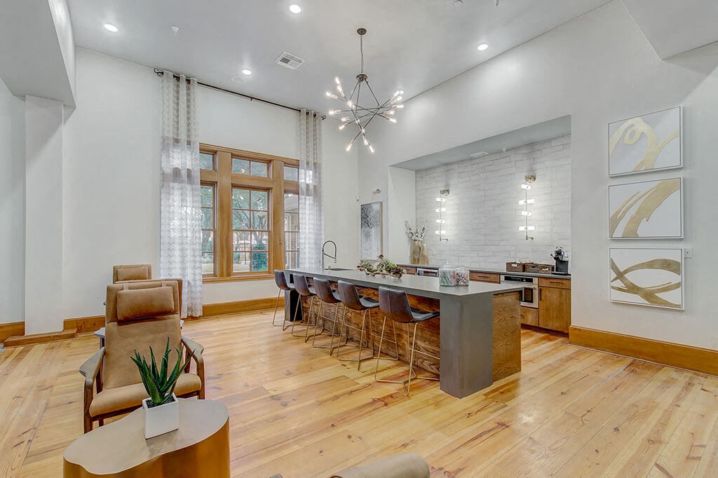 a kitchen with a long counter and a long bar with chairs