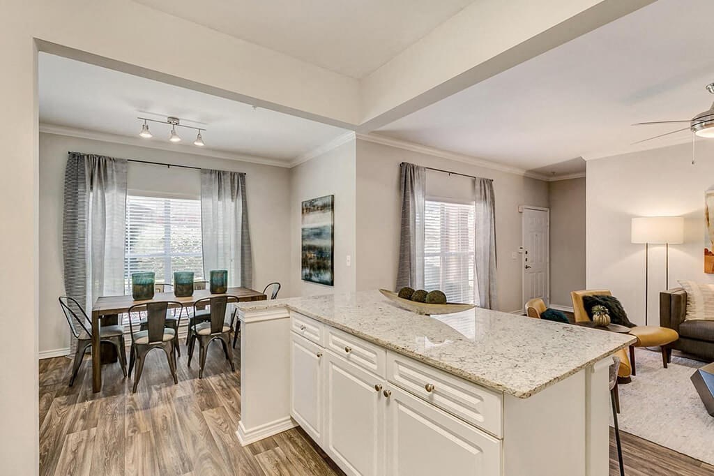 a kitchen with a counter top next to a dining room