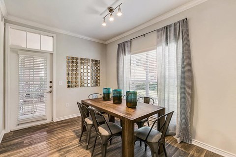 a dining room with a table and chairs and a window