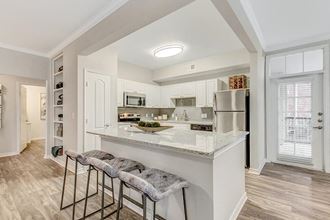 a kitchen with a counter top with three bar stools