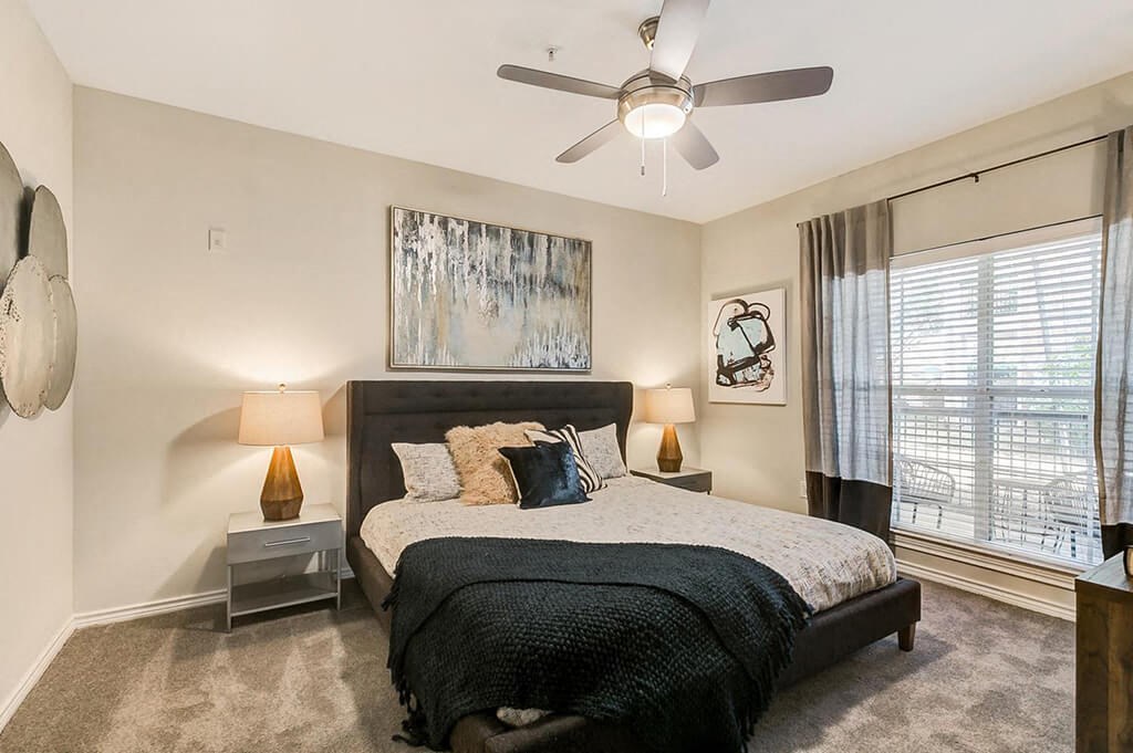 a bedroom with a bed and a ceiling fan