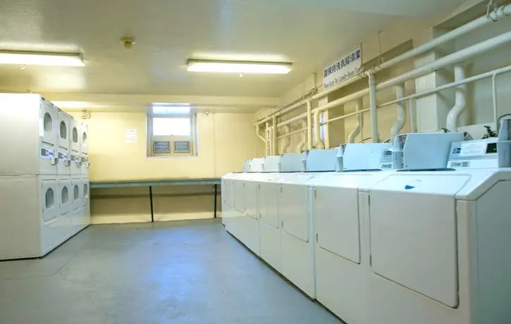 a room filled with washers and dryers in a laundromat