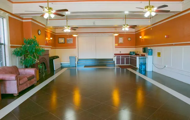 a large hall with a fireplace and chairs in it